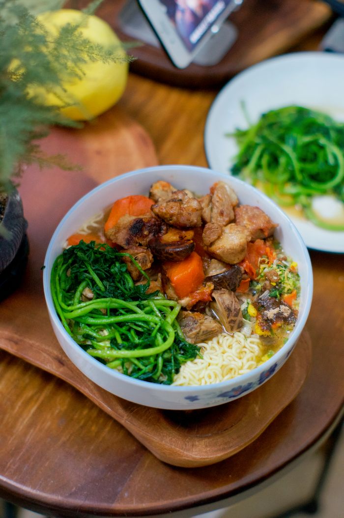 A vibrant bowl of Asian noodles with fresh vegetables and meat, perfect for a hearty meal.